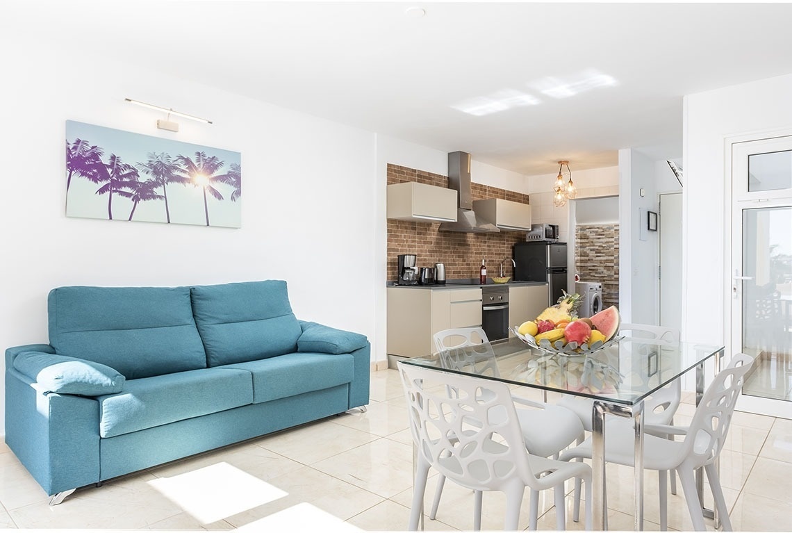 a living room with a blue couch and a glass table