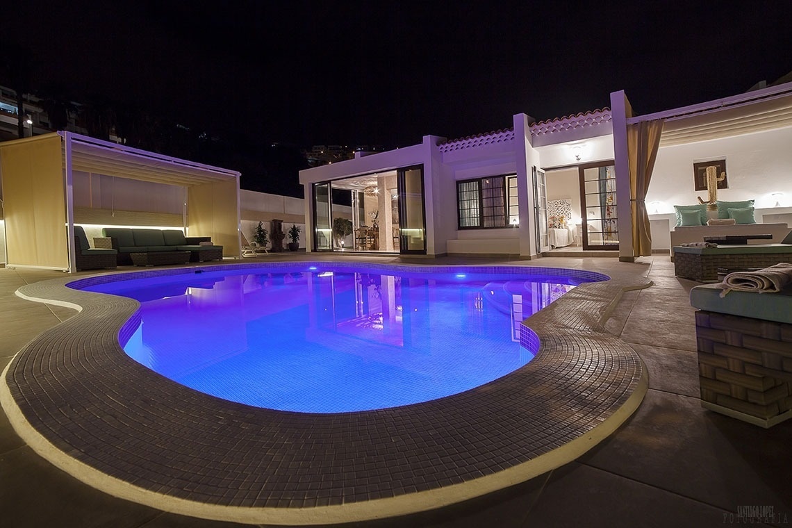 a large swimming pool is lit up at night