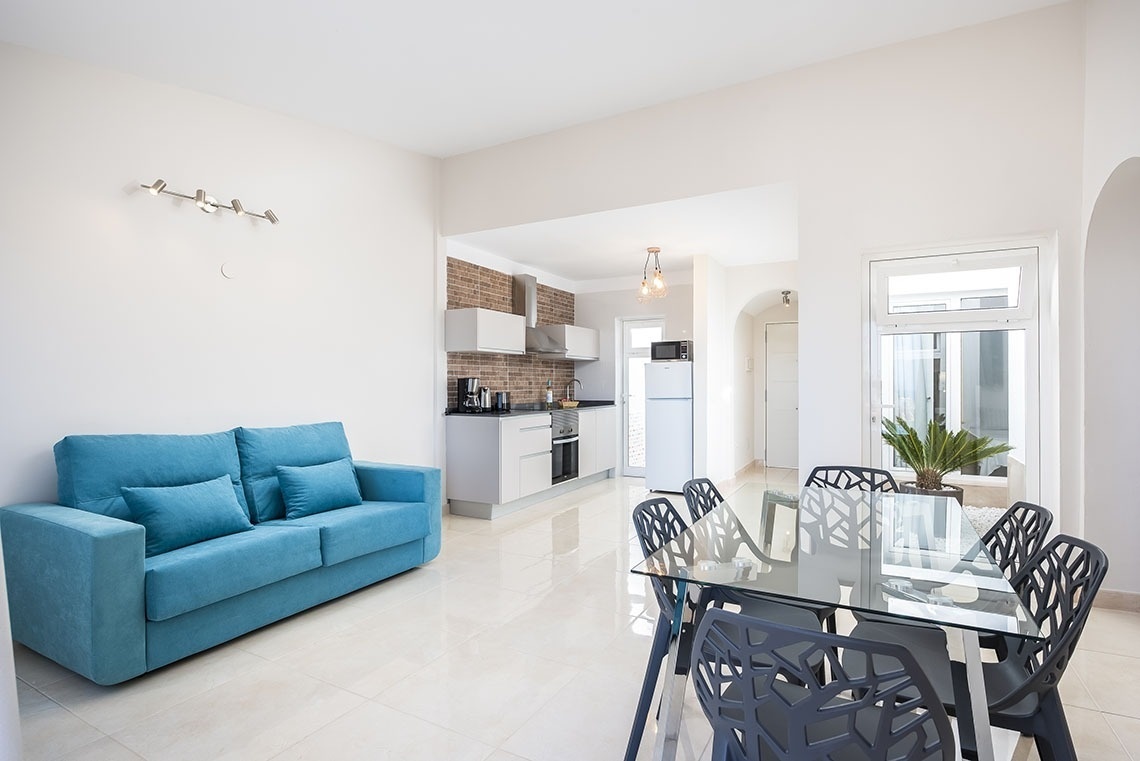 a living room with a blue couch and a glass table