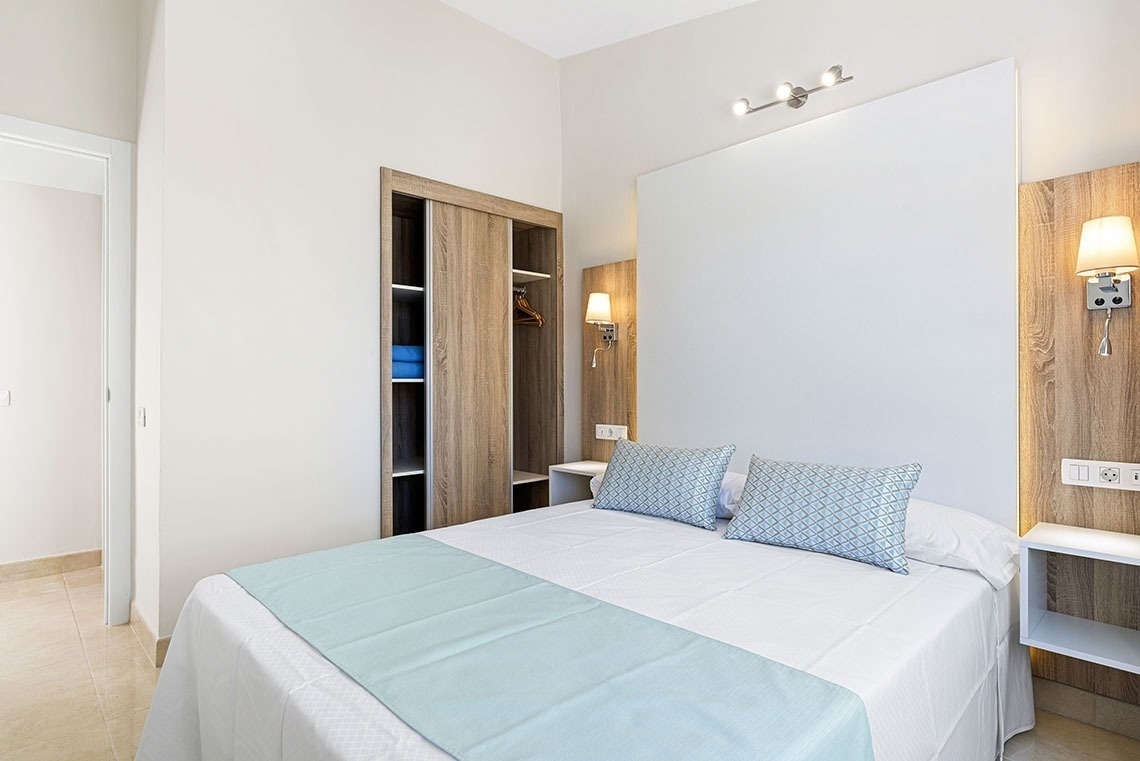a bedroom with a white bed and blue pillows
