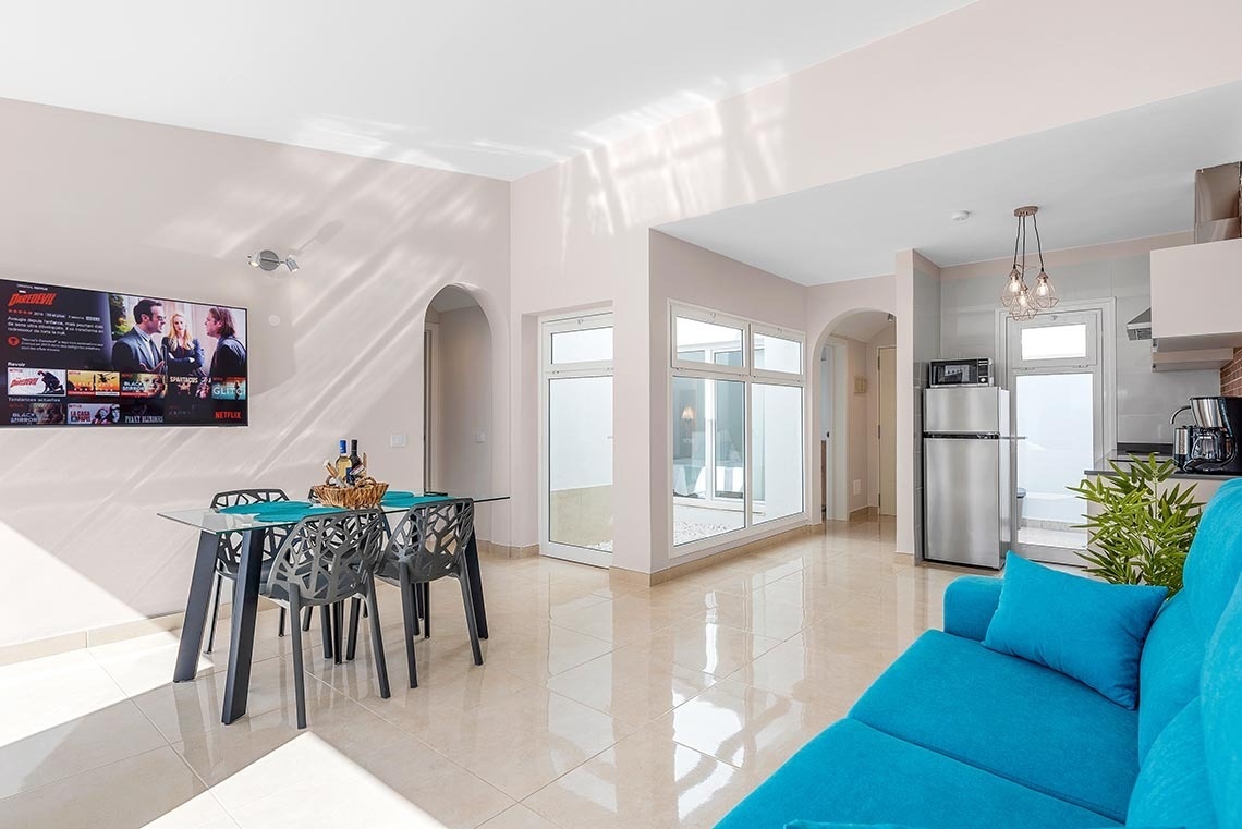 a living room with a blue couch and a flat screen tv that says netflix