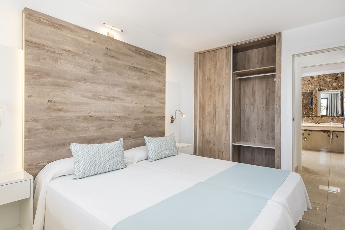 a bedroom with a large bed and a wooden headboard