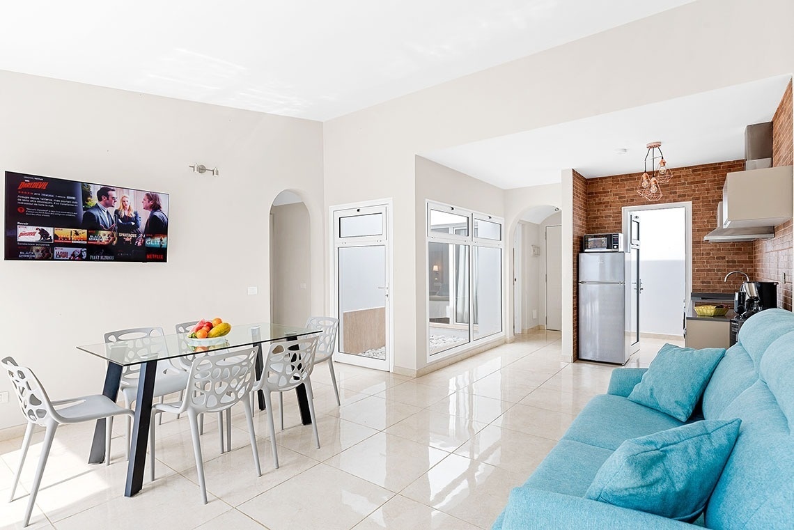a living room with a blue couch and a netflix screen