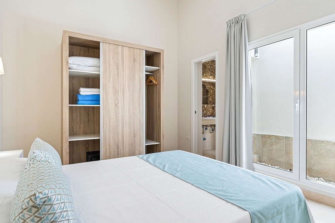 a bedroom with a bed and a closet filled with towels