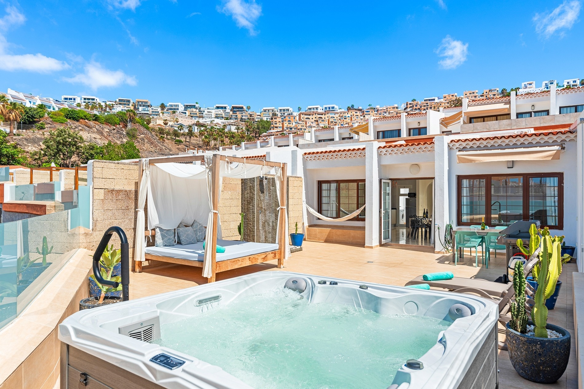 a patio with a table and chairs and a grill