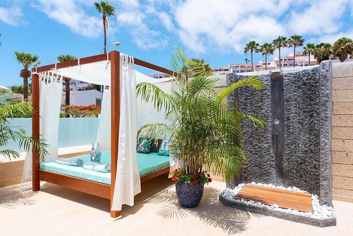 a canopy bed with a bottle of wine on it