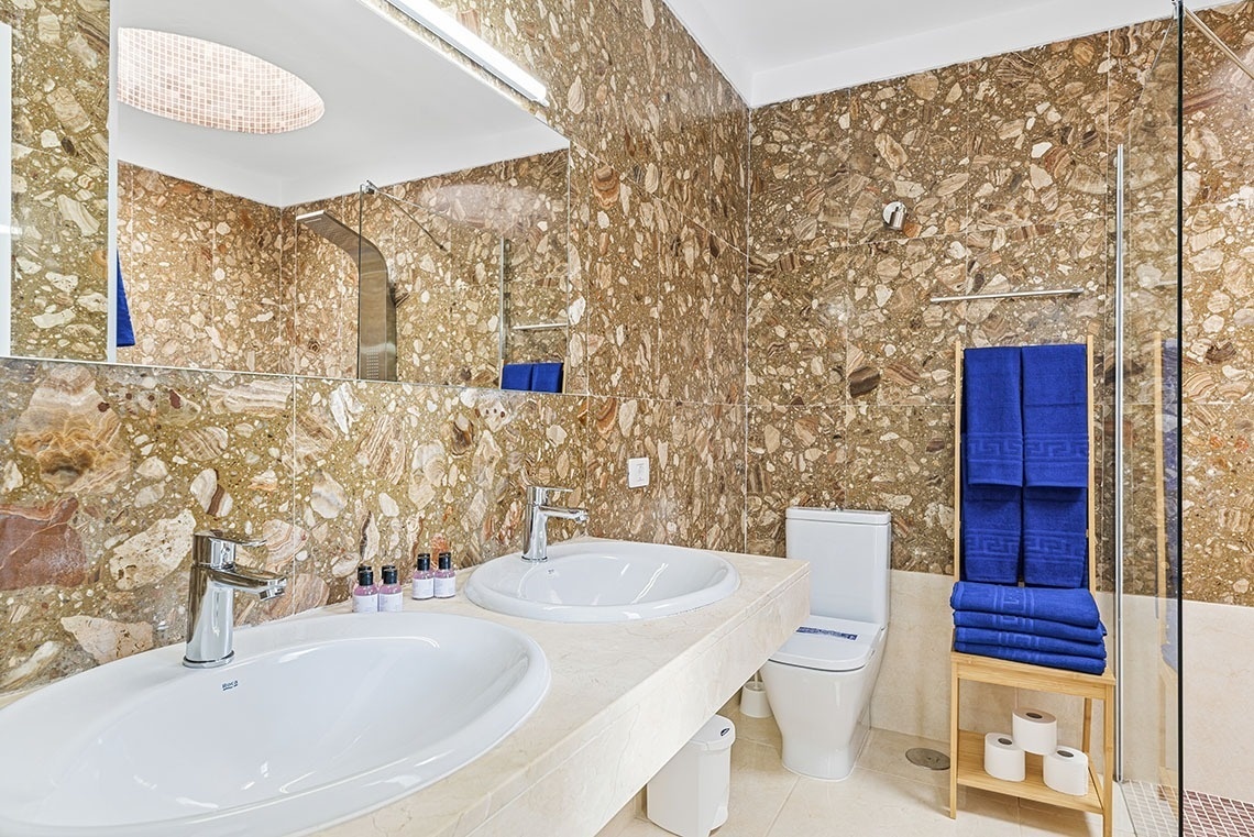 a bathroom with two sinks a toilet and a mirror