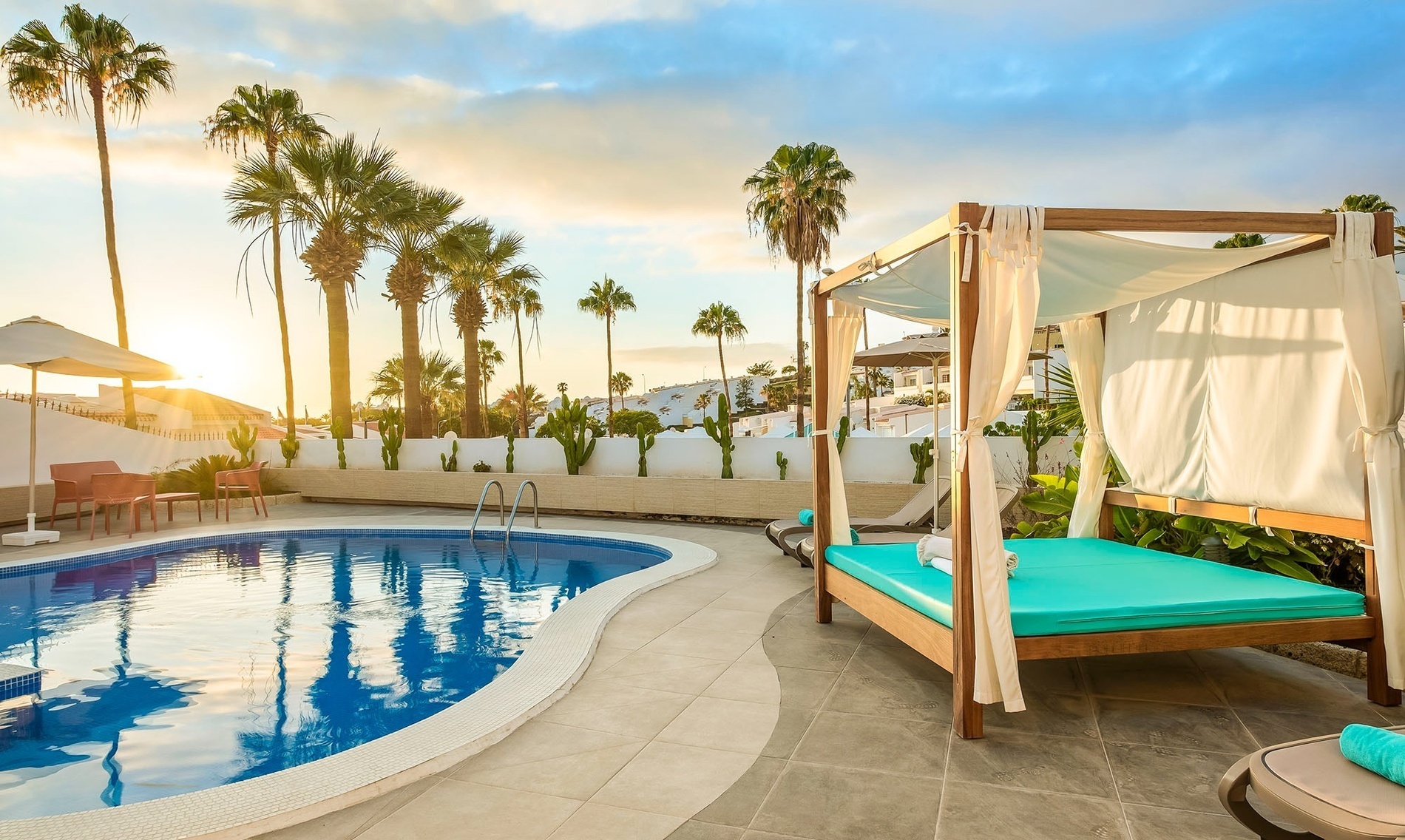 a swimming pool with a canopy bed in front of it