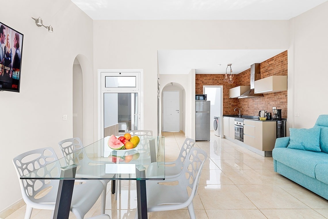 a dining room table with a bowl of fruit on it