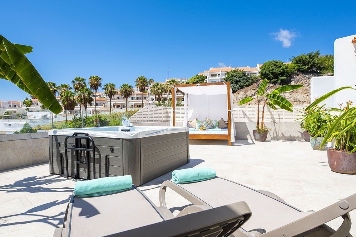 a hot tub with a canopy bed in the background
