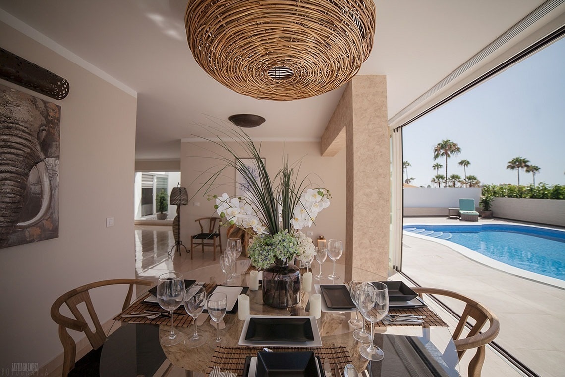 a dining room table with a vase of flowers on it