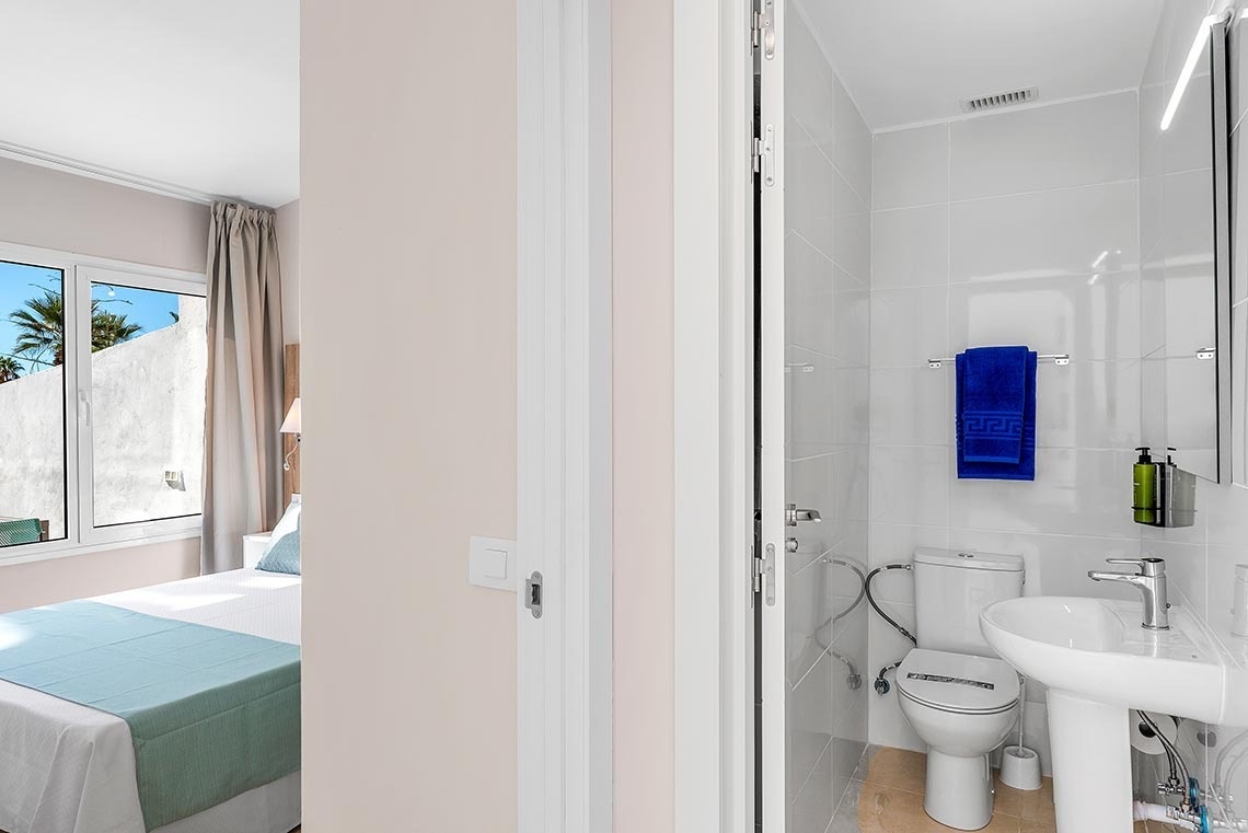 a bathroom with a toilet a sink and a blue towel on the wall