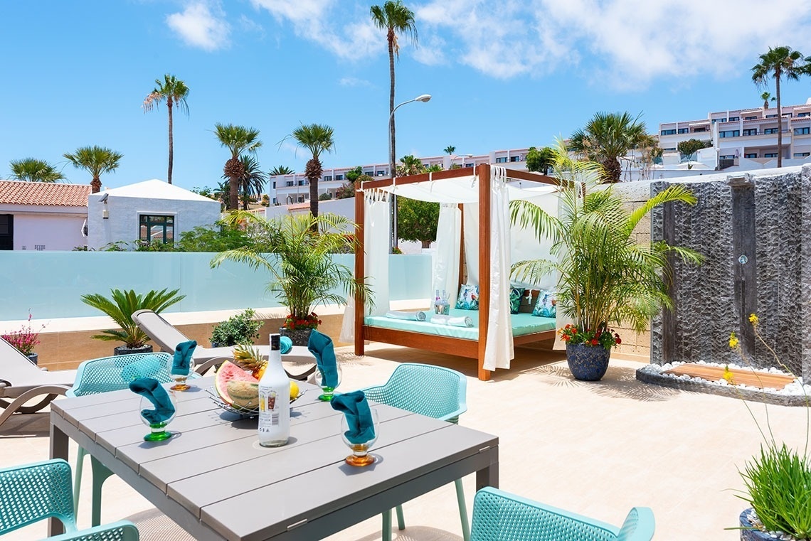 a canopy bed sits next to a table and chairs