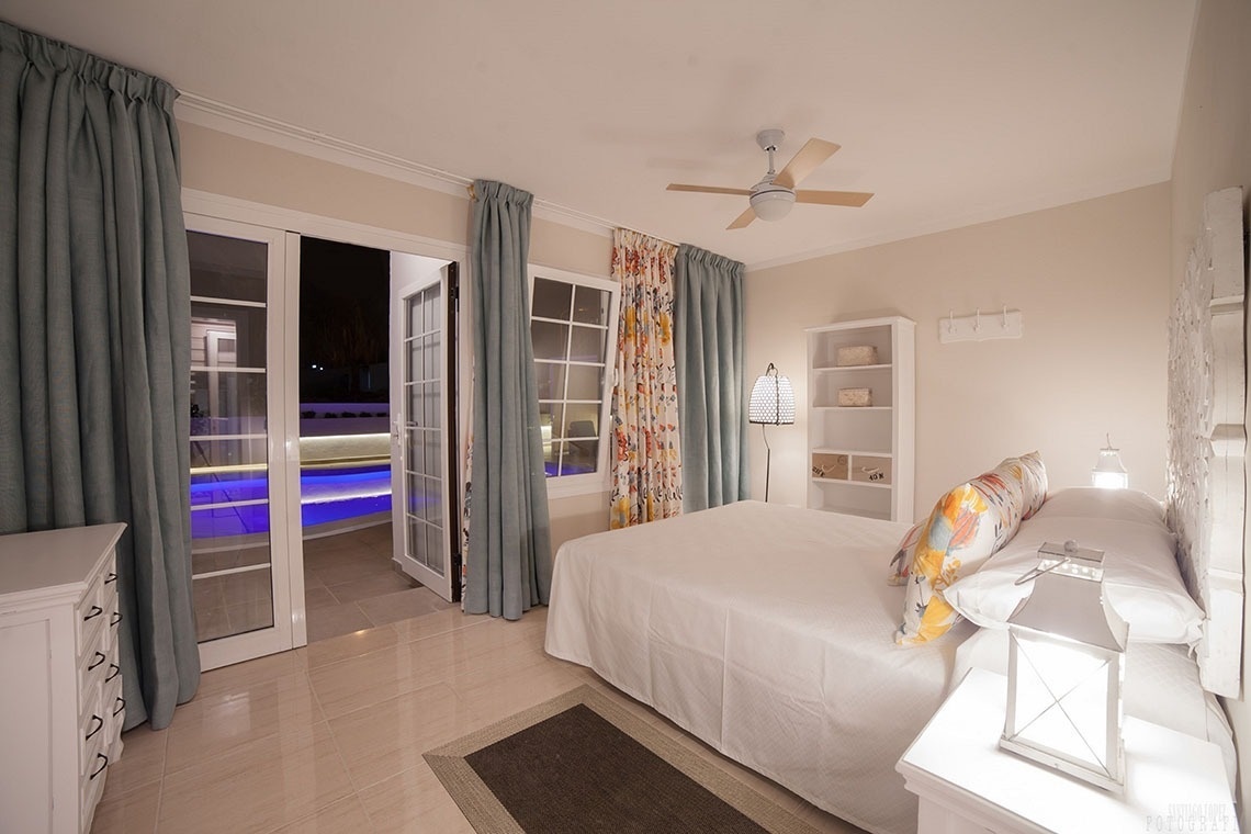 a bedroom with a large bed and a ceiling fan