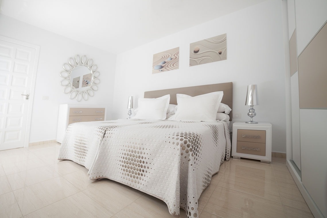 a bedroom with two beds and a mirror on the wall