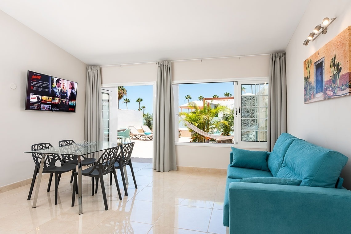 a living room with a blue couch and a flat screen tv that says netflix on it