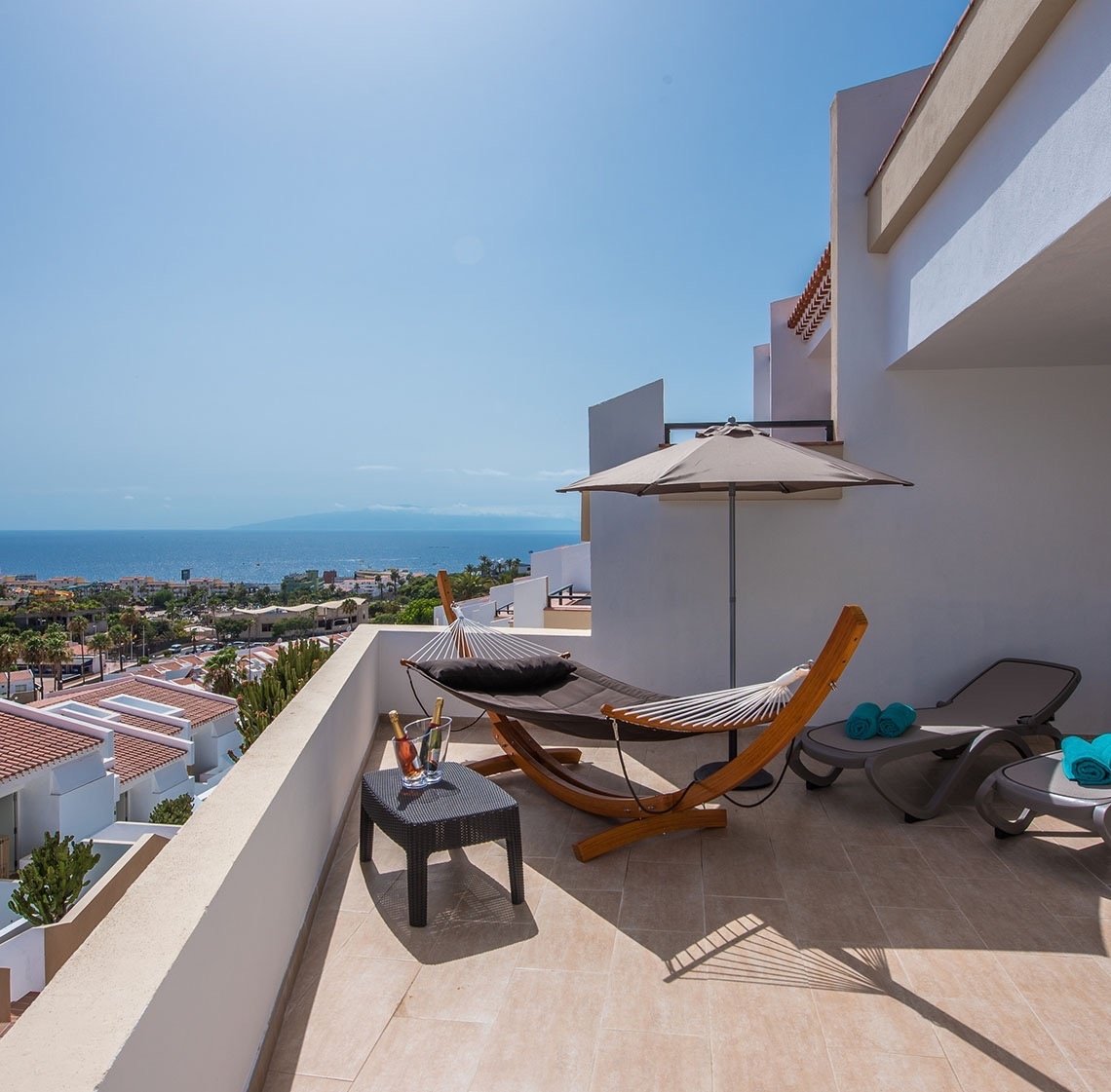 ein Balkon mit einer Hängematte und Liegestühlen