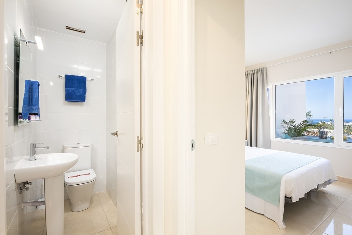 a bathroom with a toilet and a sink and a window