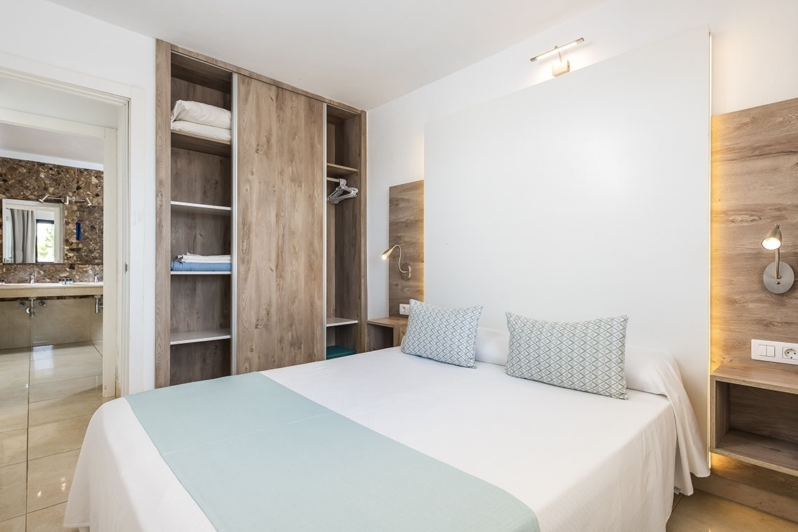 a bedroom with a bed and a closet behind it