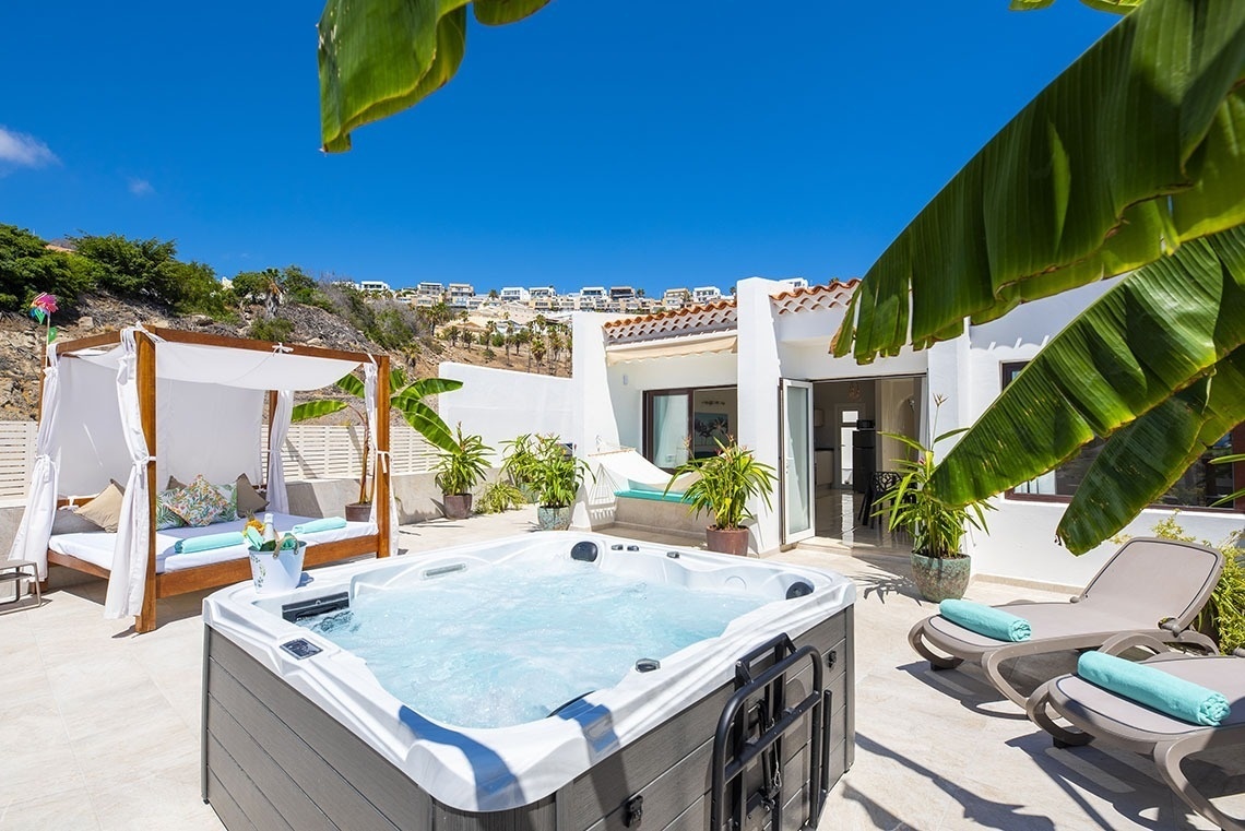 a hot tub with a canopy bed in the background