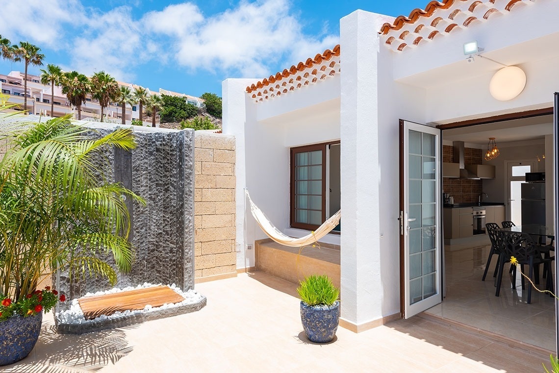 a white house with a hammock in front of it