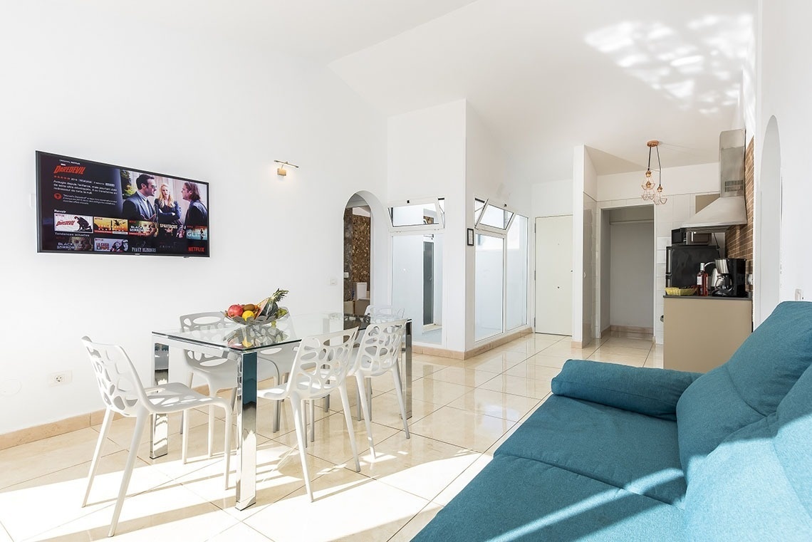 a living room with a blue couch and a netflix tv