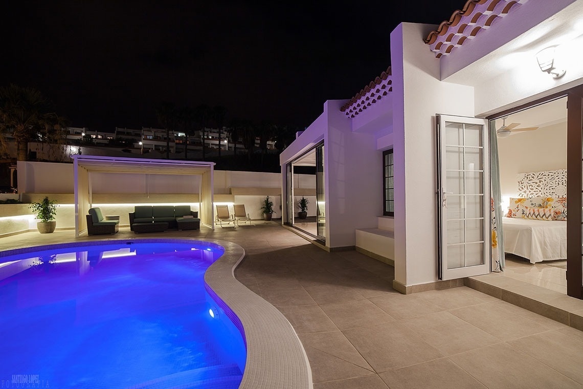 a large swimming pool is lit up at night