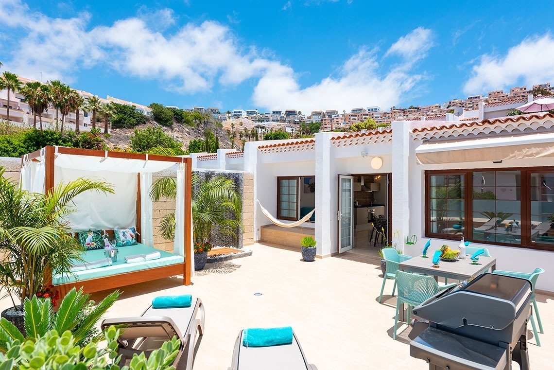 a patio with a hammock and a table and chairs