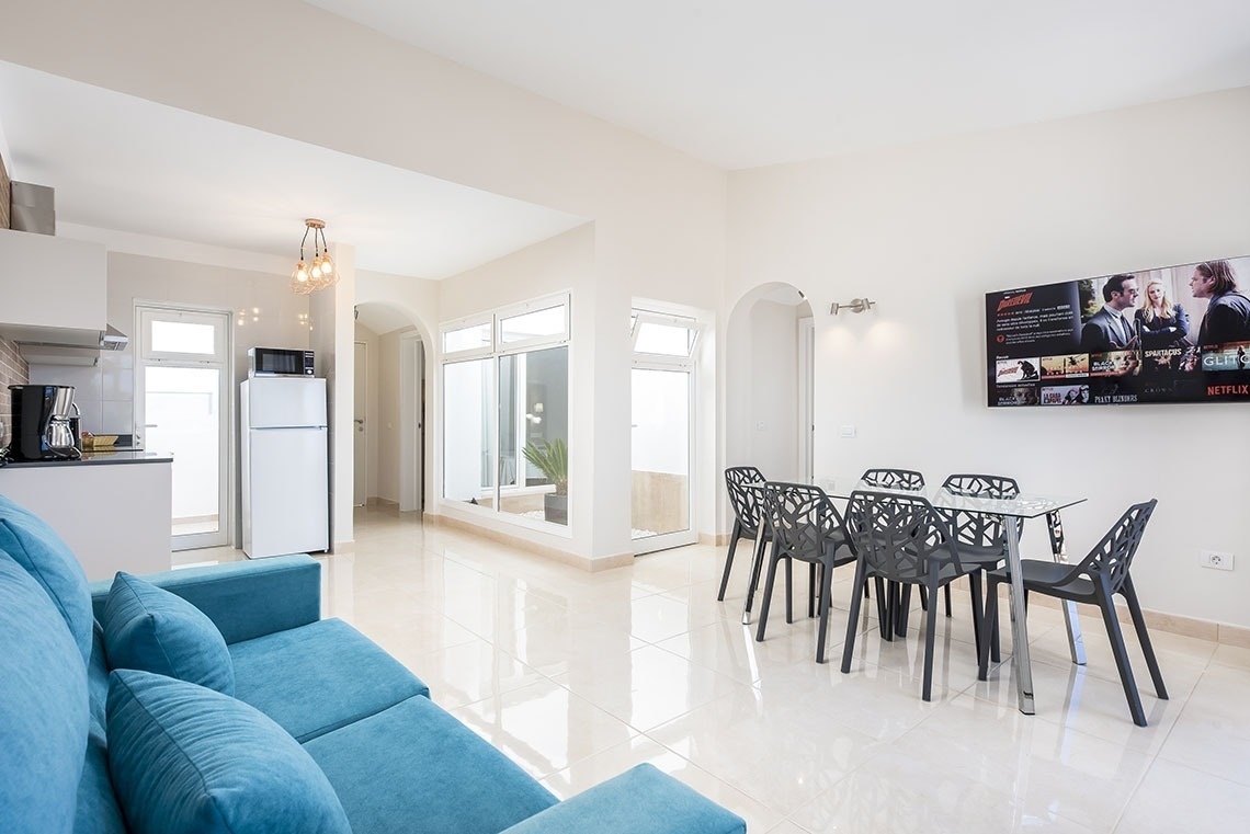 a living room with a blue couch and a tv that says netflix on it