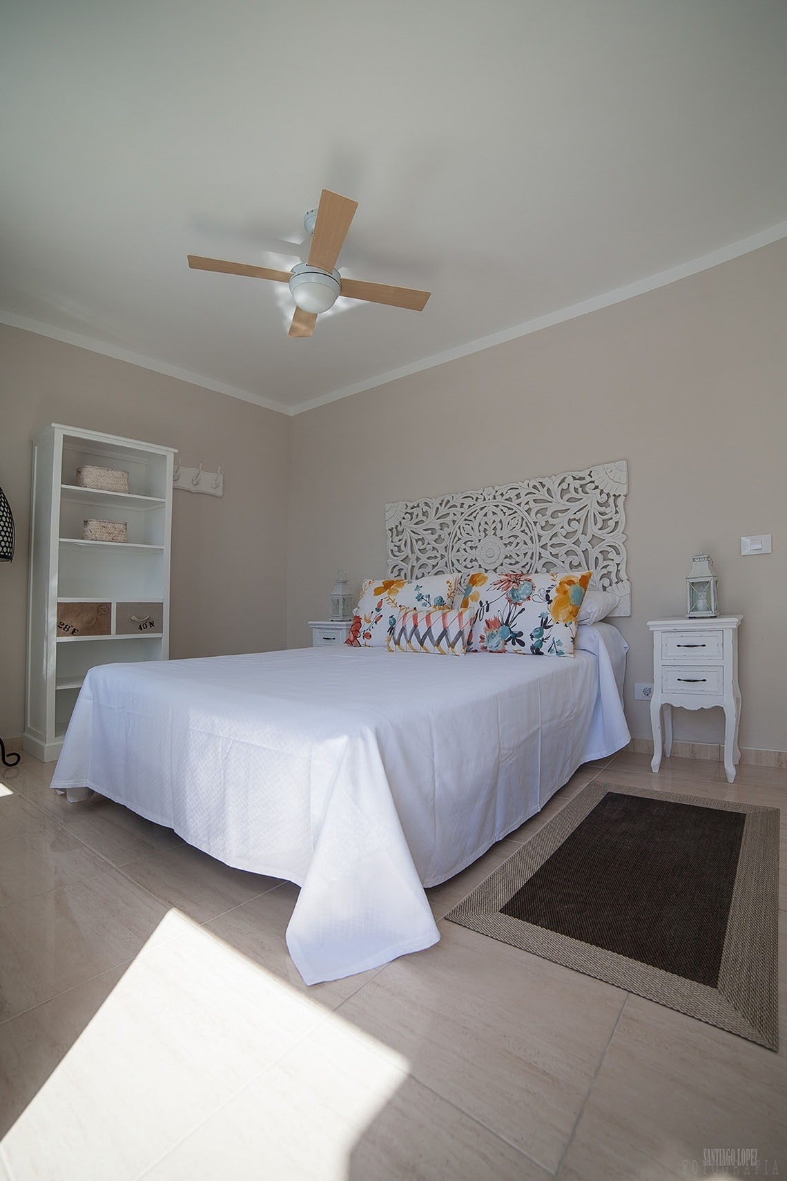 a bedroom with a large bed and a ceiling fan