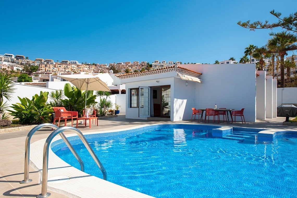 a white house with a swimming pool in front of it