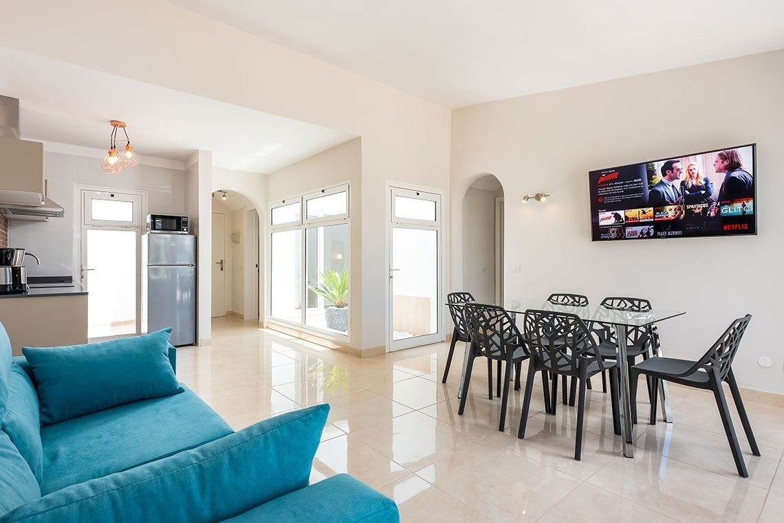 a living room with a blue couch and a netflix screen