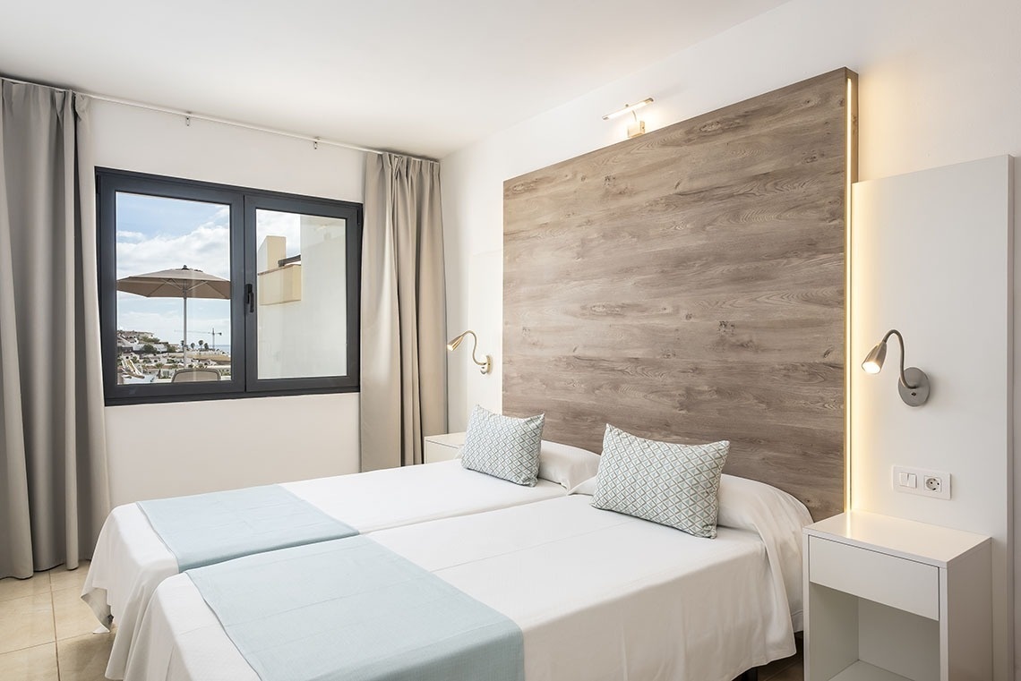 a hotel room with two beds and a window