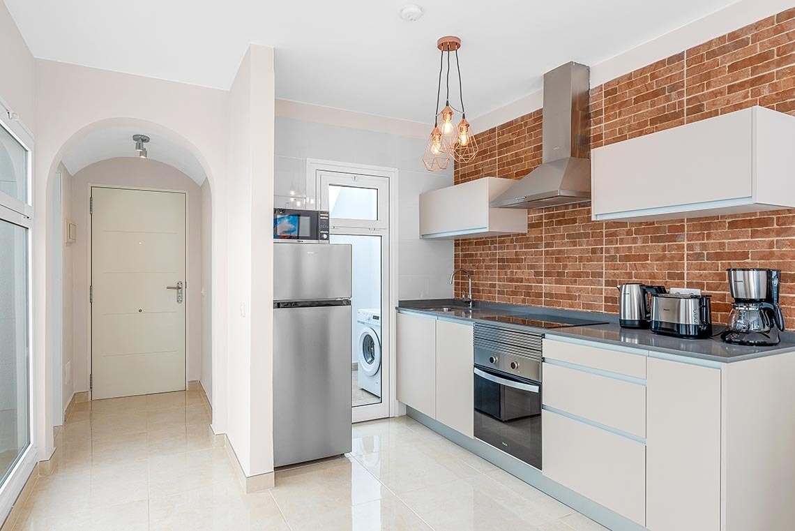 a kitchen with white cabinets and a stainless steel refrigerator