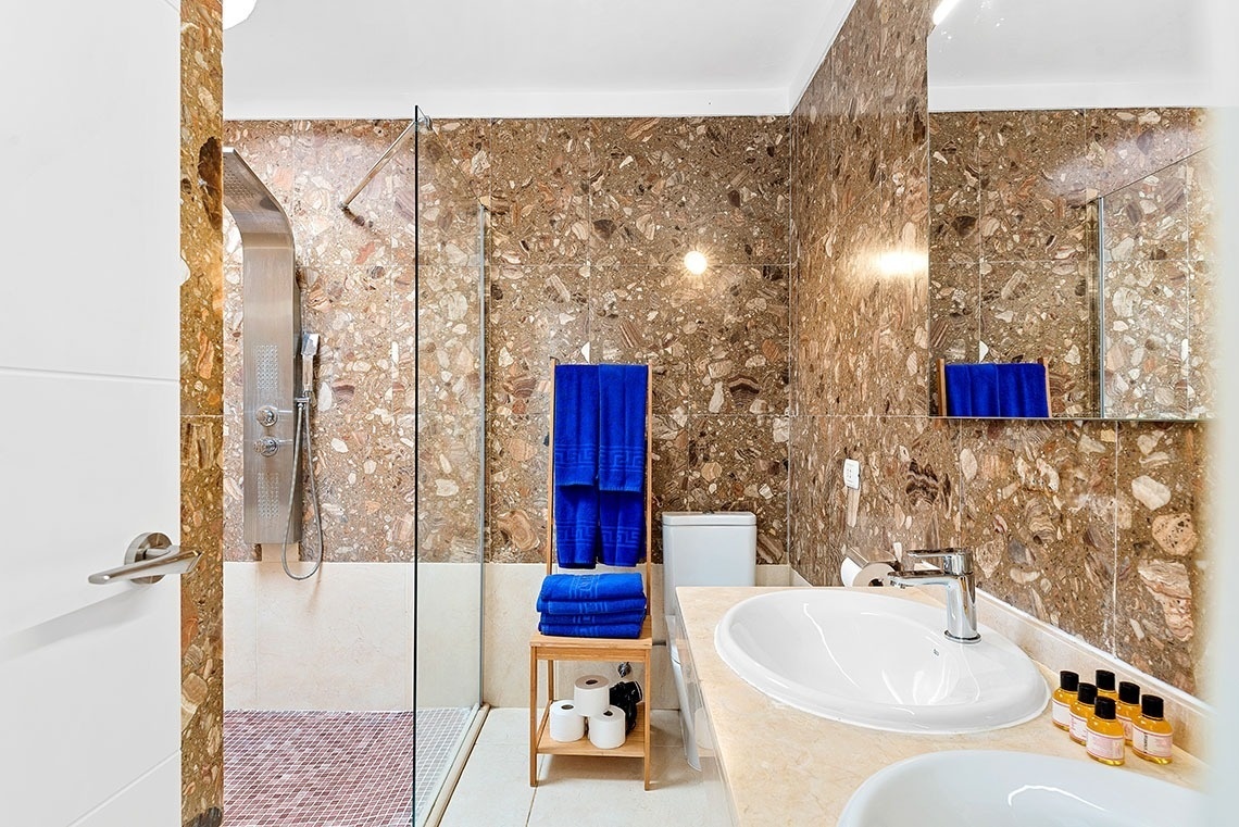 a bathroom with a walk in shower and a sink