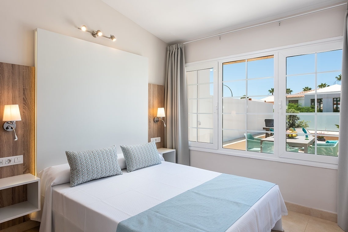 a hotel room with a bed and a large window