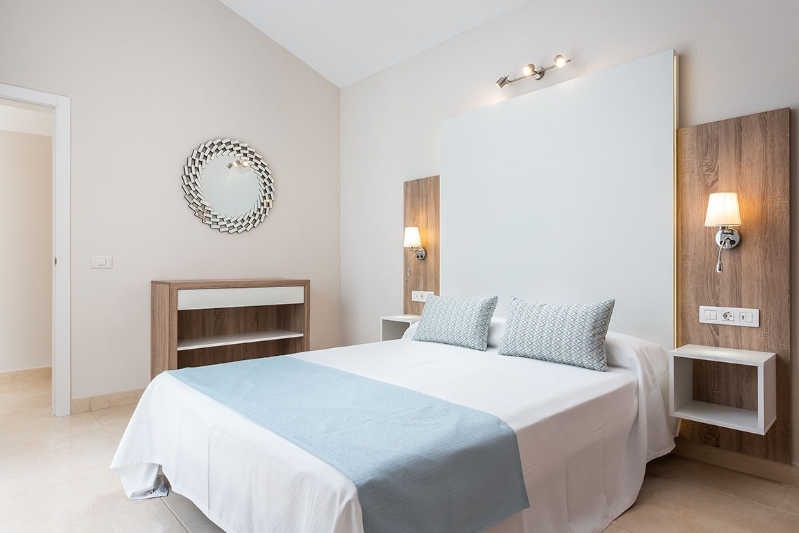 a bedroom with a bed and a mirror on the wall