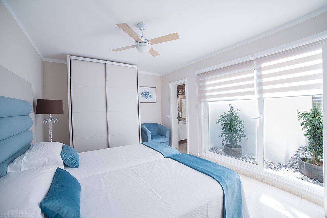 a bedroom with two beds and a ceiling fan