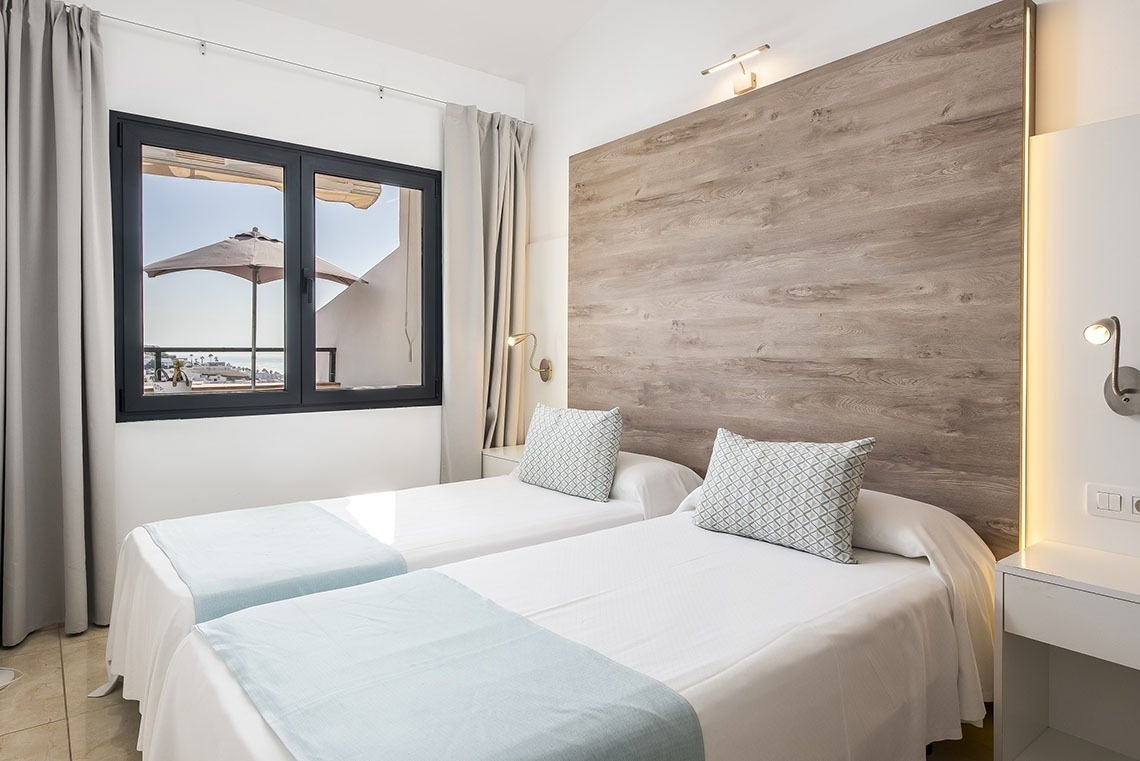 a hotel room with two beds and a window