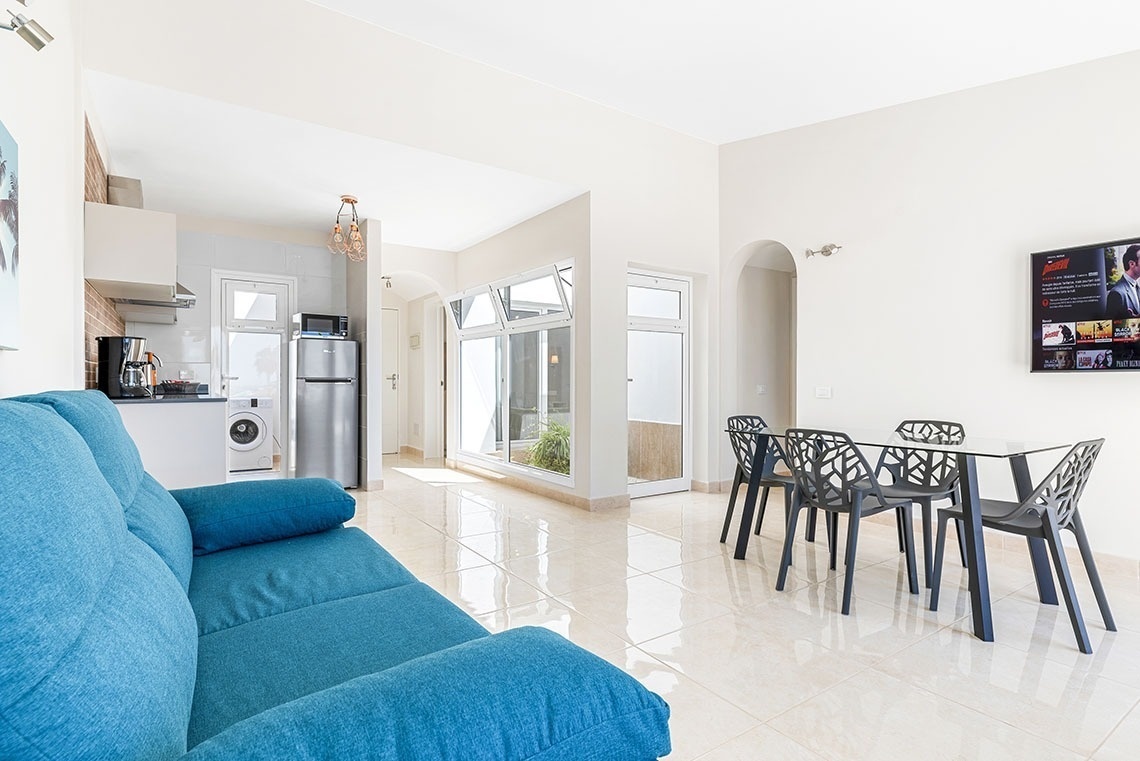 a living room with a blue couch and a tv that says netflix