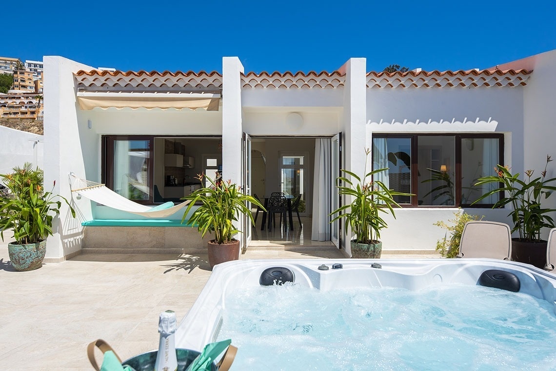 a white house with a hot tub in front of it