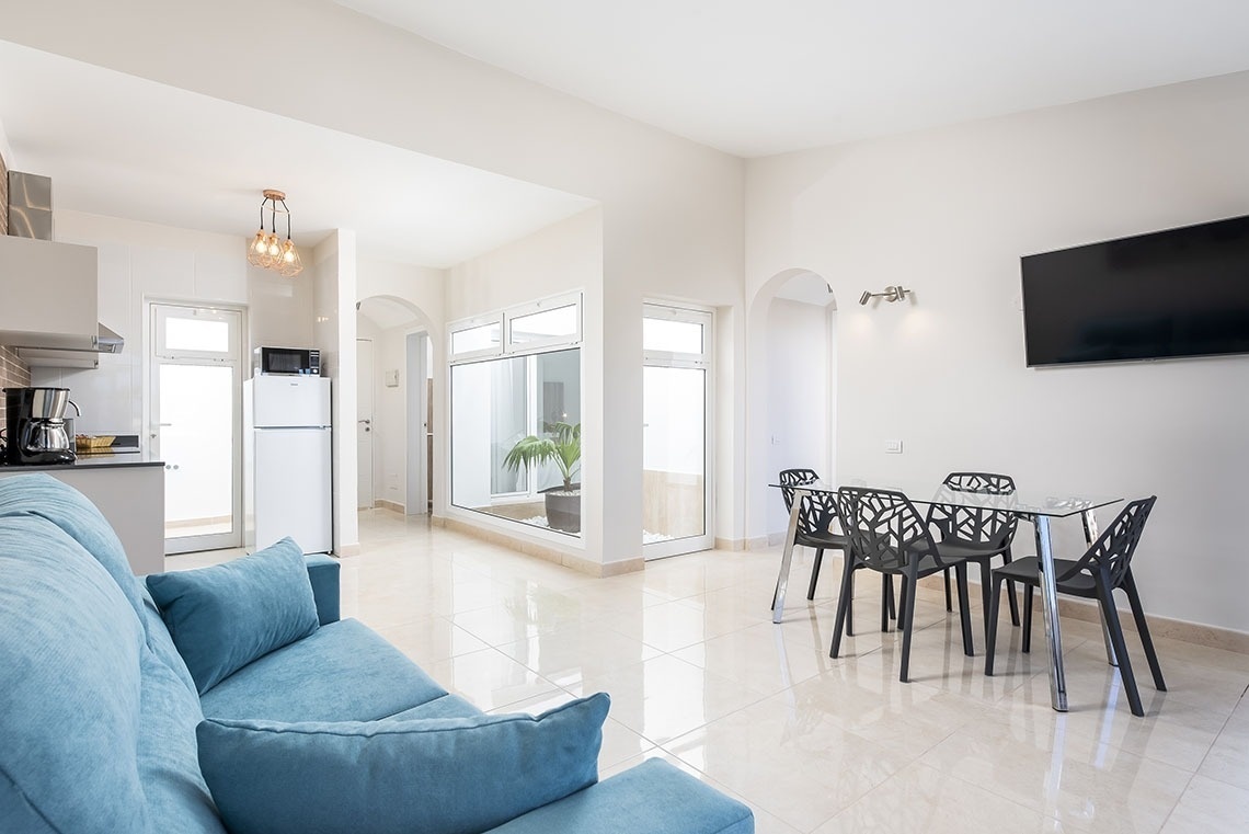a living room with a blue couch and black chairs