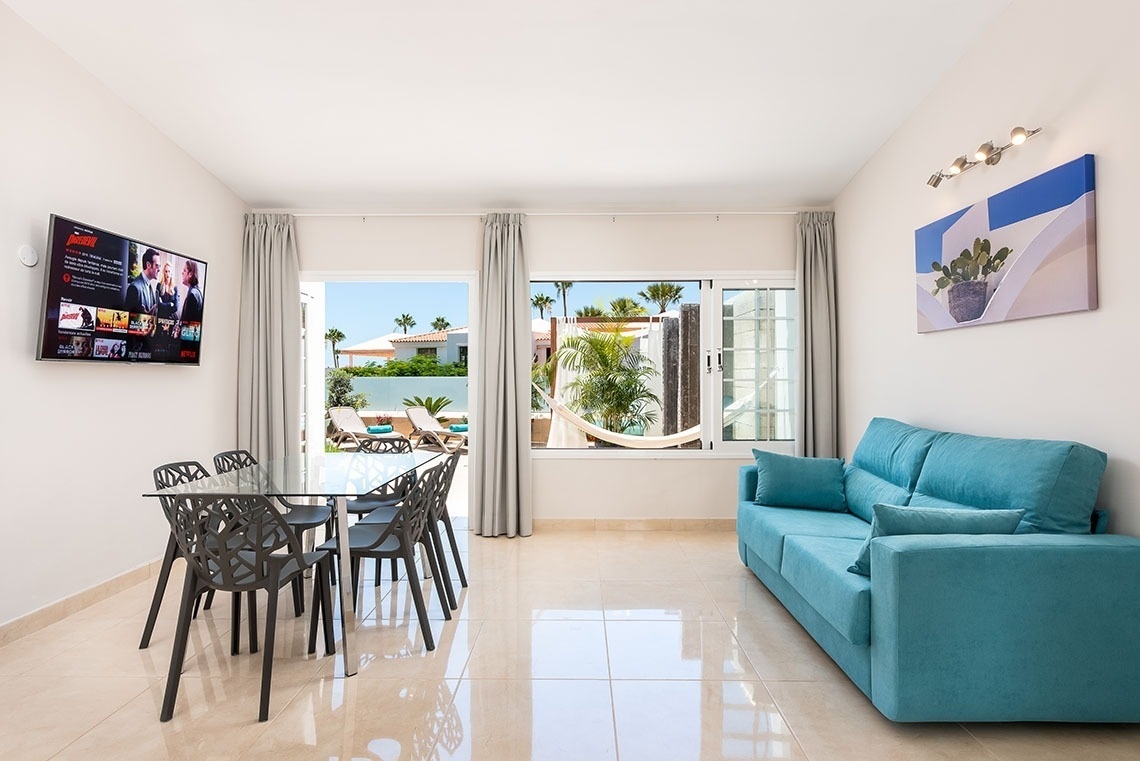 a living room with a blue couch and a netflix tv