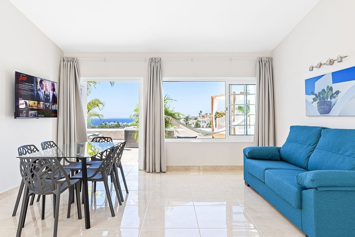 a living room with a blue couch and a flat screen tv that says netflix