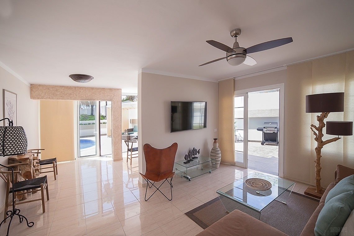 a living room with a ceiling fan and a flat screen tv