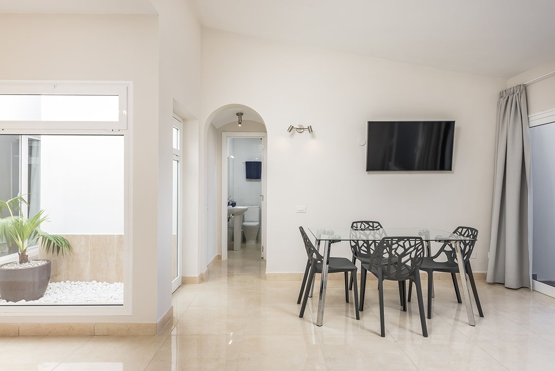 a living room with a table and chairs and a flat screen tv