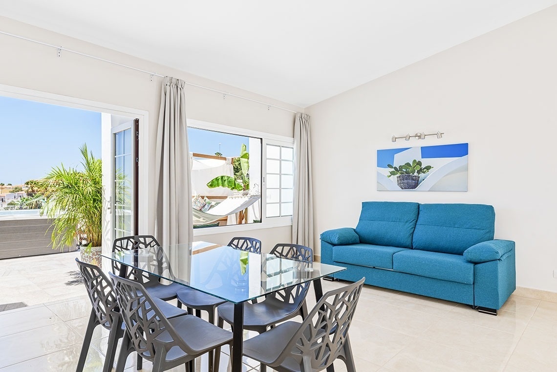 a living room with a blue couch and a glass table