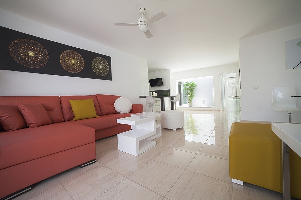 a living room with a red couch and a white table