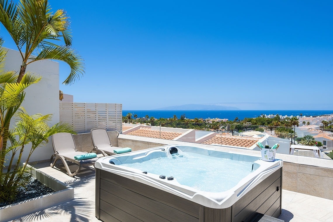 a hot tub on a balcony overlooking the ocean
