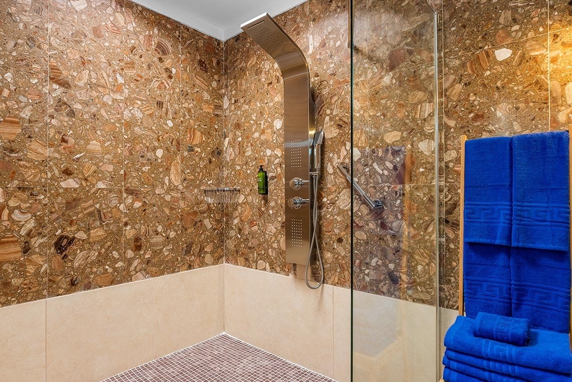 a bathroom with blue towels and a shower head